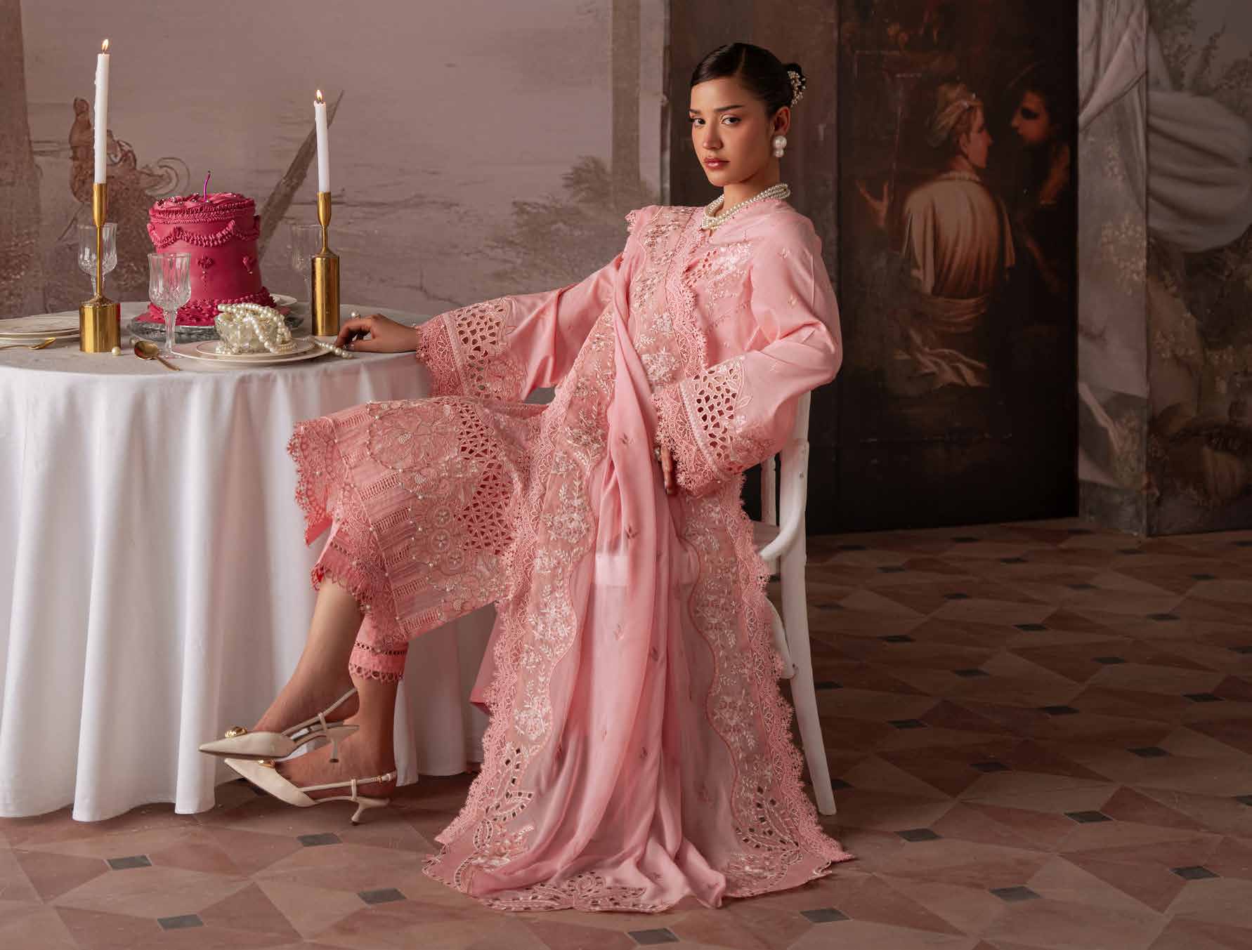 Model wearing a soft pink embroidered Pakistani outfit in a styled campaign setting